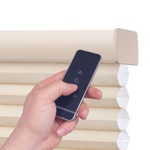 Hand holding remote for motorized shades