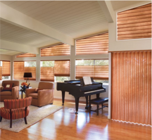 A bright room with plantation shutters alongside a grand piano shows how soft window coverings blend with elegant interiors