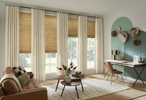 Living room with draperies and top treatments paired with woven shades, adding softness, height, and a tailored finish to the windows