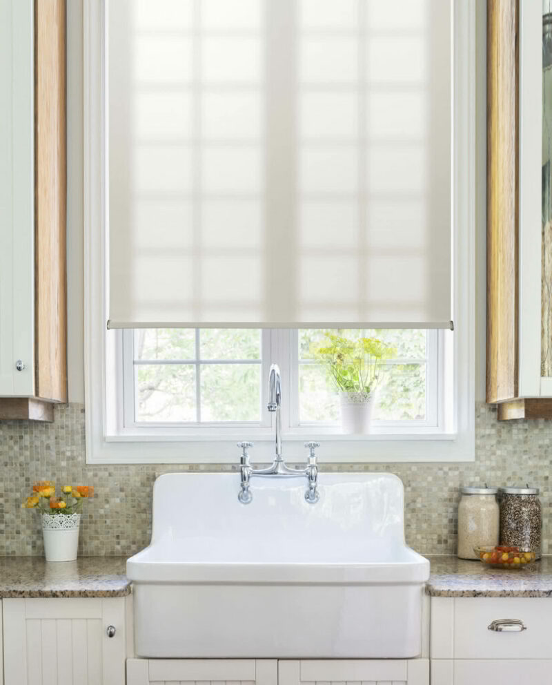 White roller shades above a kitchen sink offering light control and a clean design