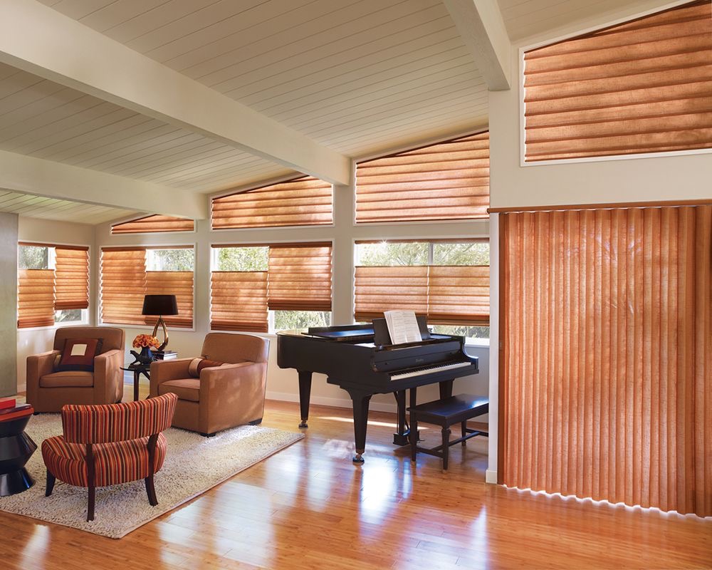 Bright living room with a grand piano and multiple windows fitted with plantation shutters in a warm wood tone for a classic and elegant look