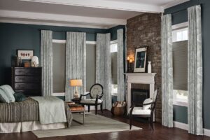 Elegant bedroom featuring draperies and top treatments paired with cellular shades, adding layered style, privacy, and warmth to the space