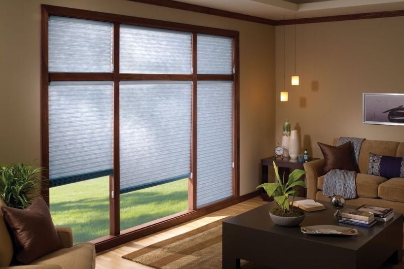 Cozy brown living room featuring cellular shades installed on the windows for light control and insulation.