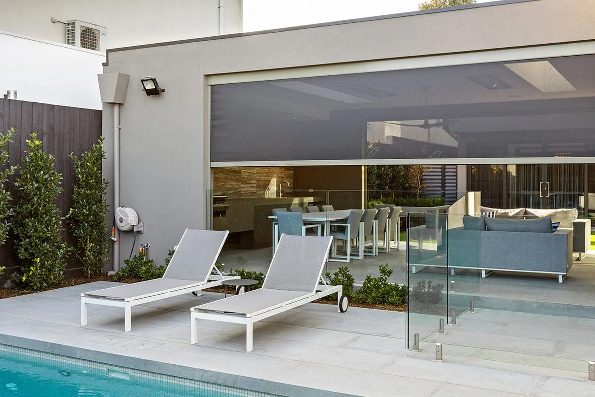Rollease Acmeda exterior zip screen partly lowered over a poolside patio